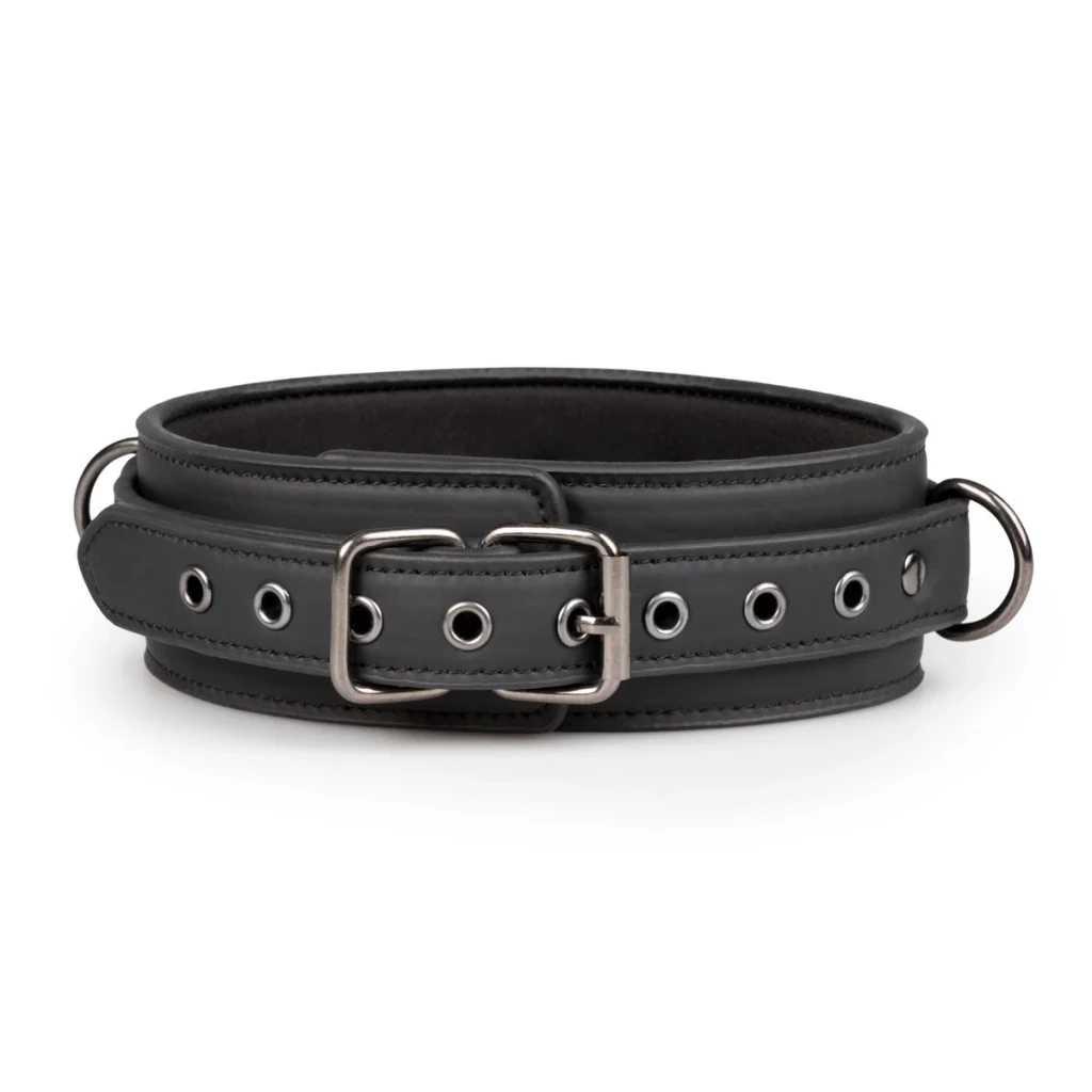 Close view of the black leather collar from the cuff set, showing its broad band, adjustable buckle strap, metal eyelets and side rings.