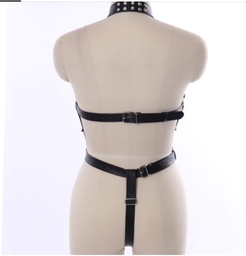 Rear view of black leather body harness on a mannequin showing open back, buckled upper and waist straps, and an adjustable lower center strap.