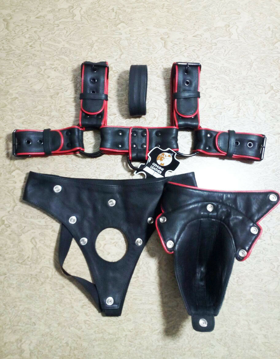 Black and red leather harness set with the jockstrap front cover detached, showing snap fasteners, a circular opening and buckle adjustments.