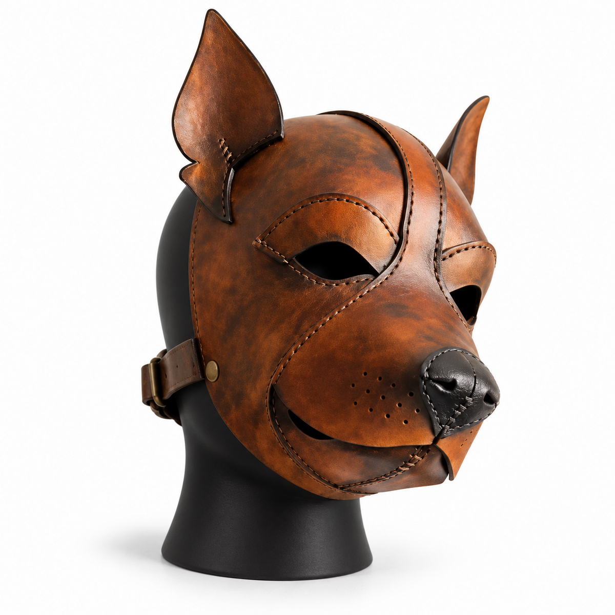 Angled view of a distressed brown leather canine mask with pointed ears, open eyes, black nose, perforated muzzle and visible side buckle.