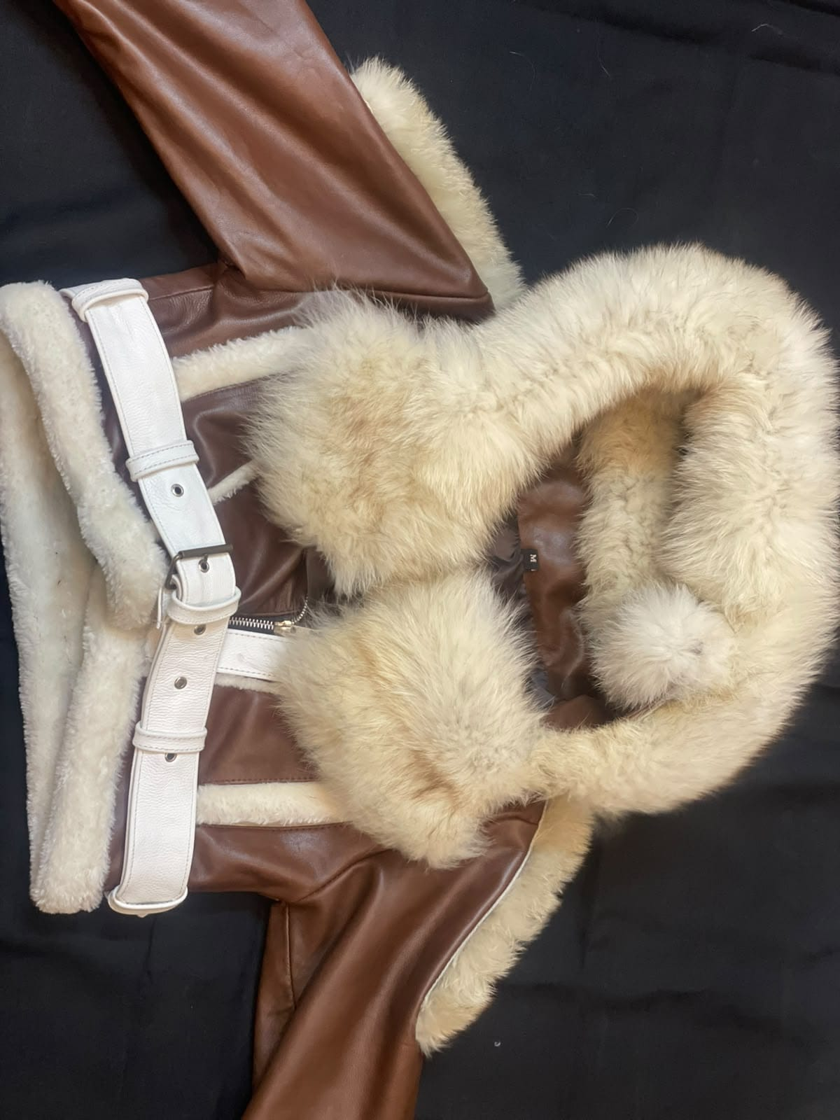 Men's brown hooded leather aviator jacket, front view showing cream plush trim, a front zipper, and a contrasting white buckle belt.