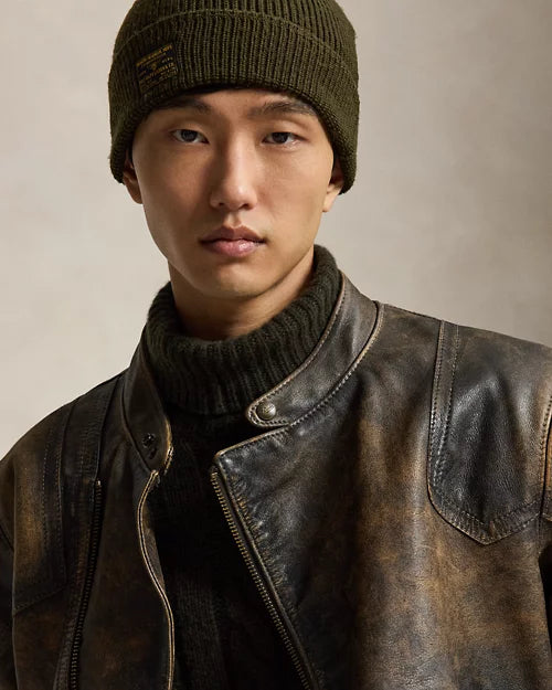 Close-up of men's distressed brown leather cafe racer jacket showing the snap stand collar, shoulder overlay panels and weathered finish.