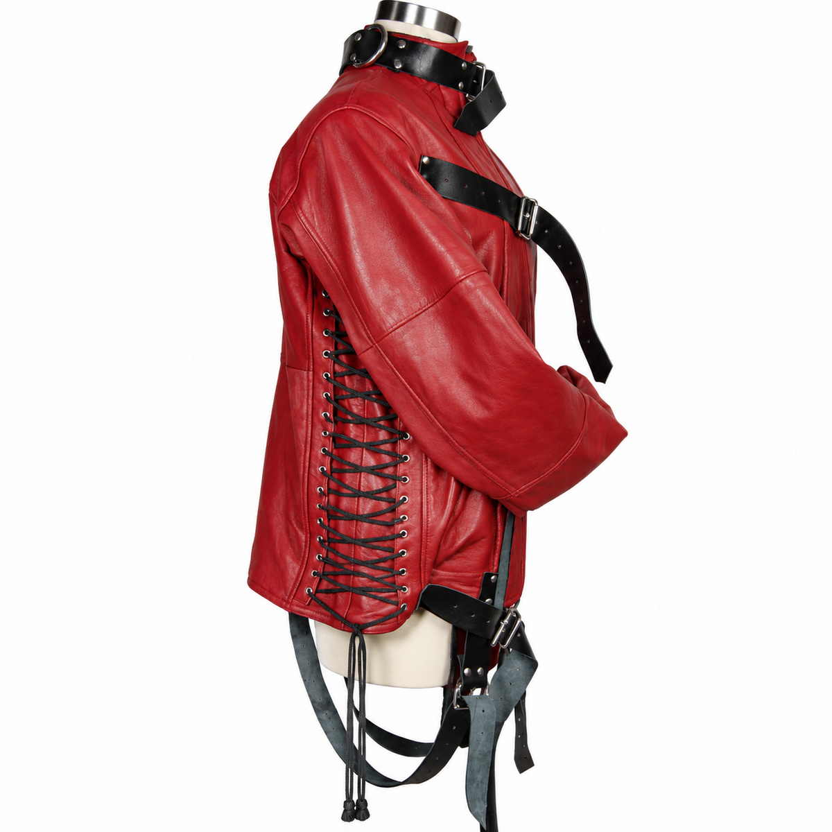 Side view of red leather straitjacket showing black eyelet lacing, buckle collar, long sleeve, contrast straps and silver-tone hardware.