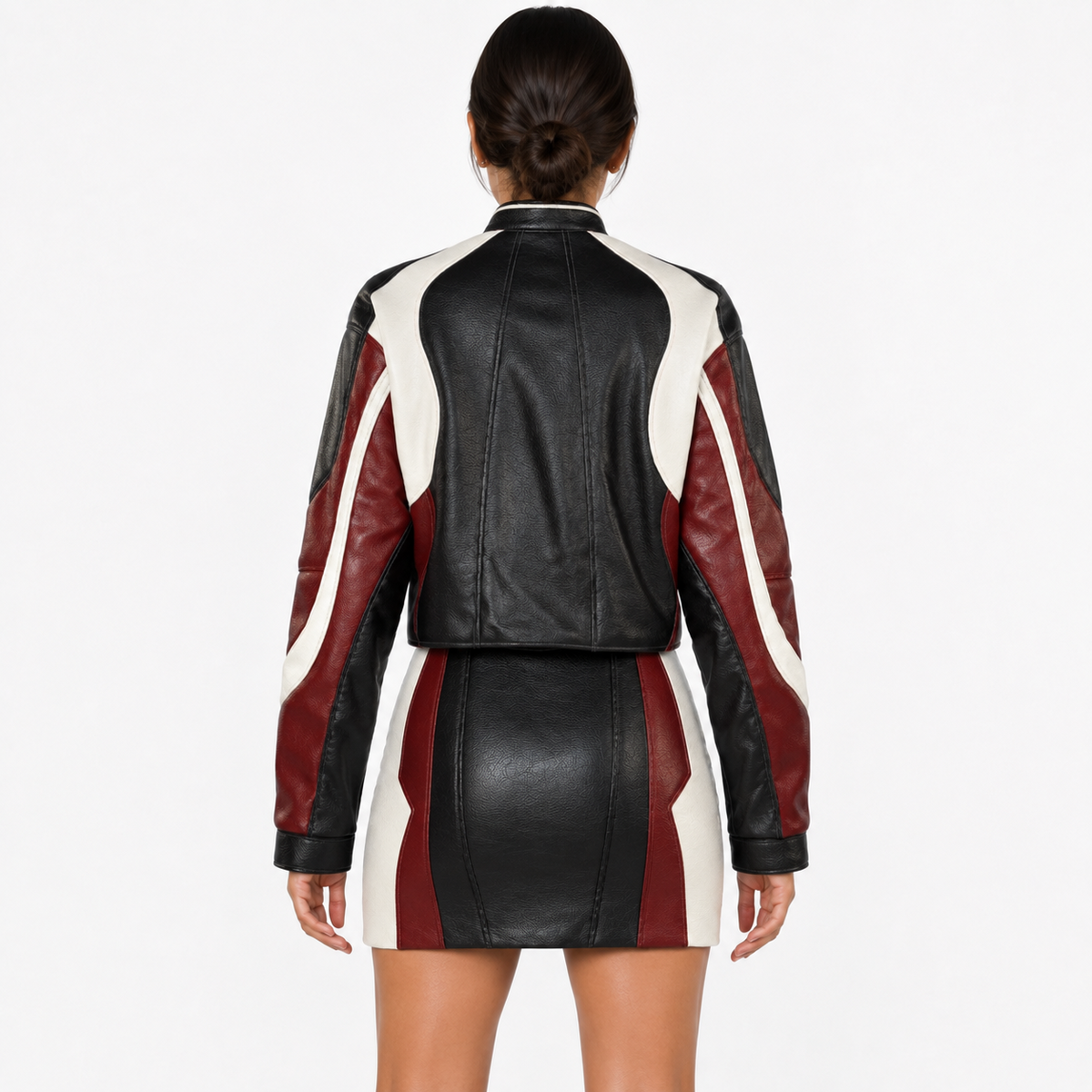 Rear view of women’s black, burgundy and white leather jacket and mini skirt set showing contrast panels, long sleeves and shaped seams.