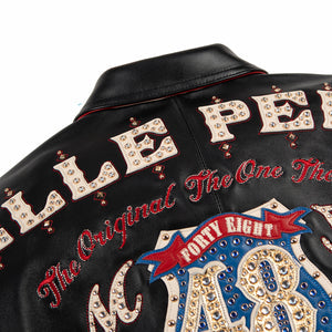 Women's black leather anniversary bomber jacket, upper back lettering detail, with red and blue crest artwork and decorative gold-toned accents.