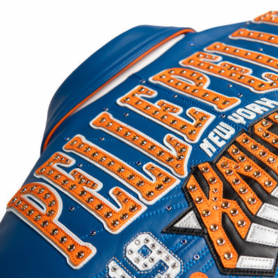Women's blue and orange leather varsity jacket, back lettering close-up, showing New York basketball graphics and contrasting decorative details.