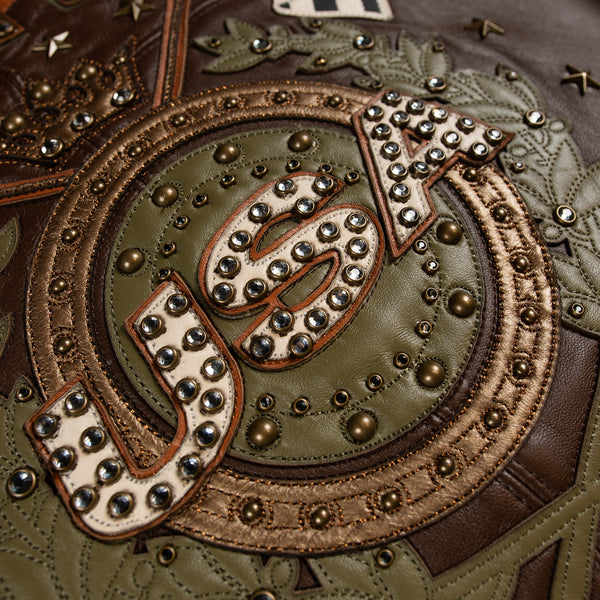 Women's brown colorblock leather racing jacket, central back motif detail, with caramel and olive panels and decorative metallic accents.
