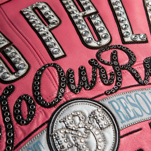 Women's pink and black leather varsity jacket, back artwork close-up, featuring contrast panels and decorative lettering in the product photo.