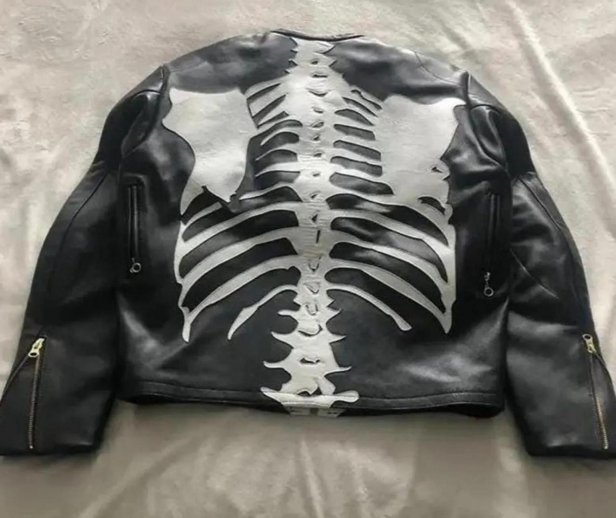 Men's black leather skeleton applique jacket, back view with contrasting spine, shoulder blade and rib details plus visible sleeve zippers.