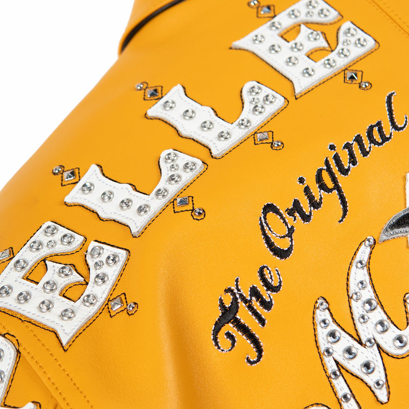 Upper back detail of maize yellow jacket with white embellished lettering, black script and small silver-tone geometric accents.