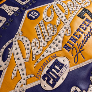 Back detail of purple leather varsity jacket showing large cream script applique over a gold diamond panel with metallic embellishments.