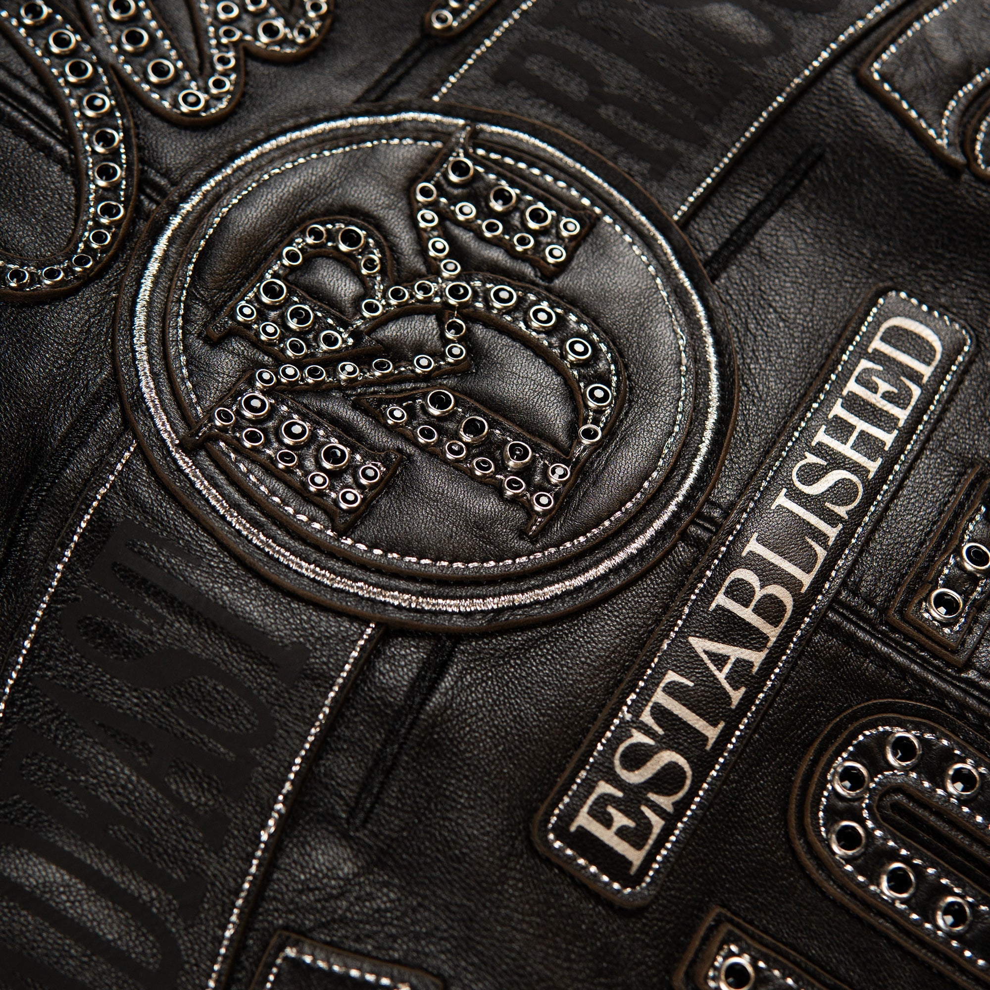 Studded black-on-black leather jacket back panel with silver-outlined lettering, banner crest and 1978 numerals