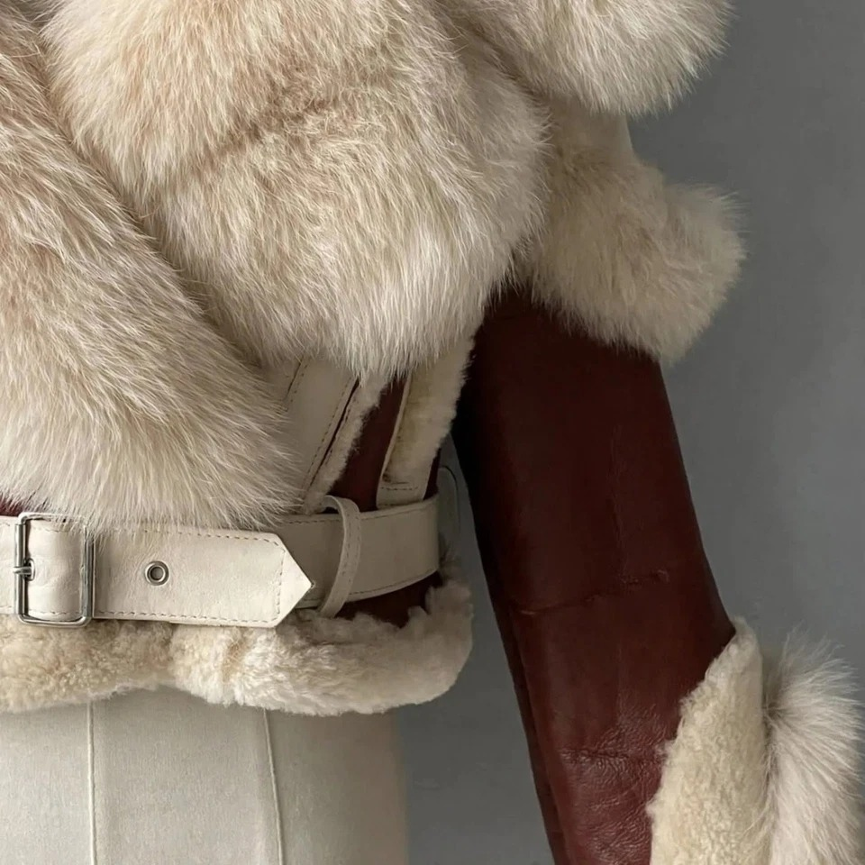 Men's cropped brown leather hooded jacket, close-up showing the light buckle belt, brown sleeve panel, and contrasting cream plush trim.