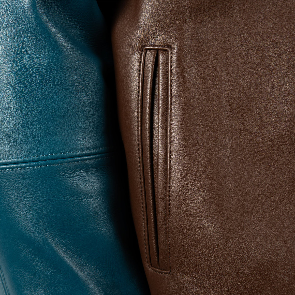 Handmade two-tone leather bomber jacket, brown body, teal raglan sleeves, ribbed 