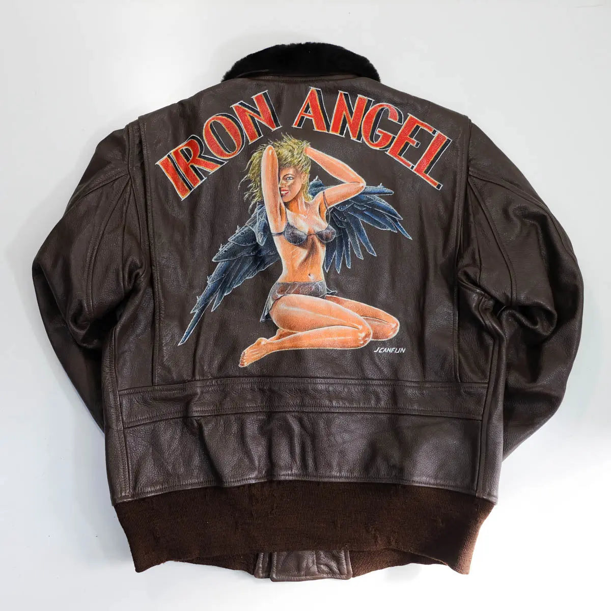 Vintage brown genuine leather flight jacket showing large Iron Angel pin-up artwork on back panel with classic bomber style