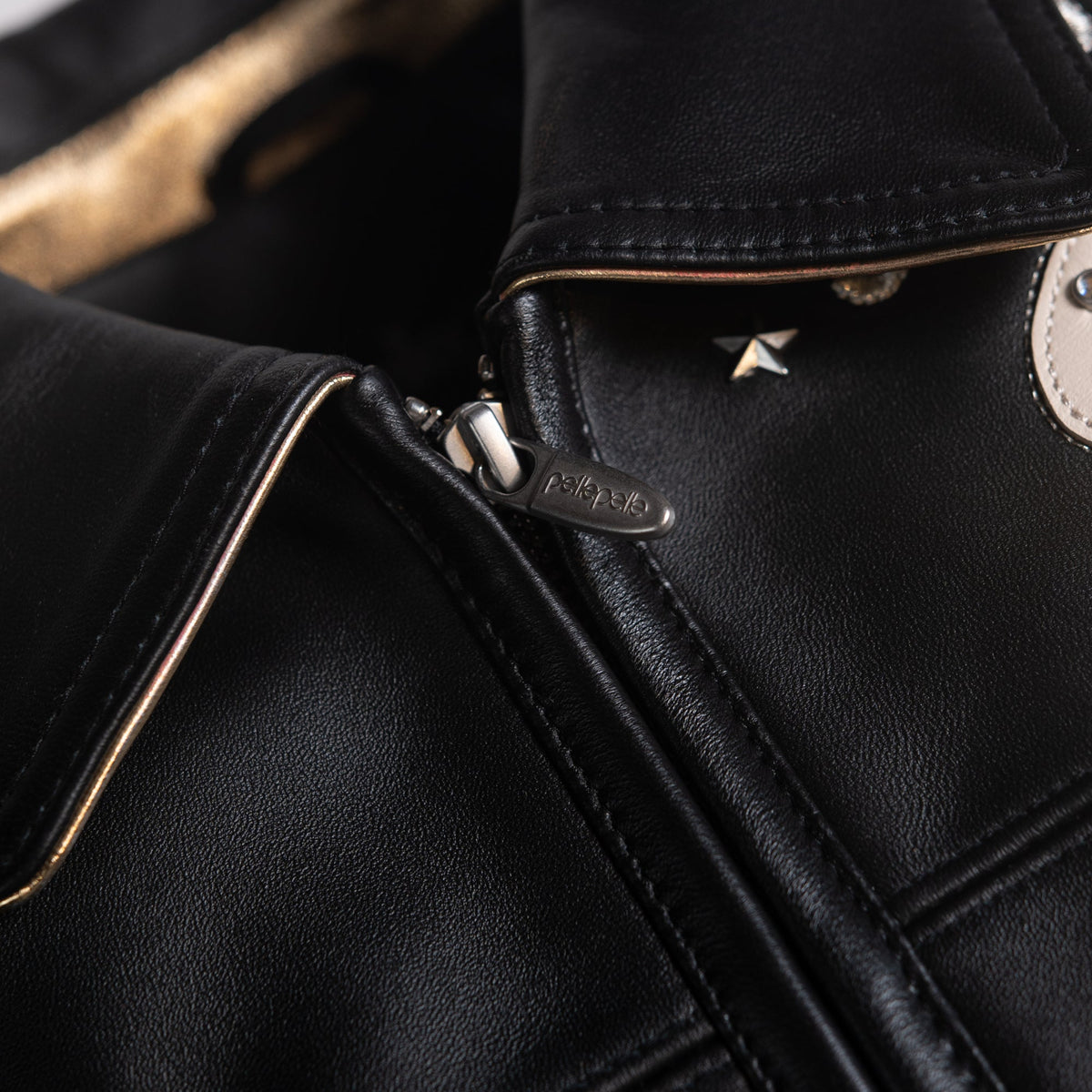 Women's black leather varsity jacket, collar and zip close-up, showing contrasting cream accents and decorative details in the supplied product photograph.