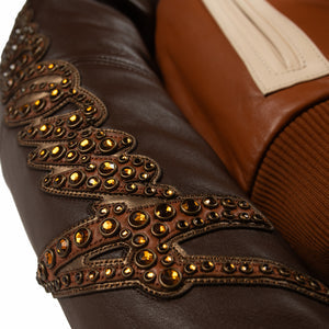 Women's brown colorblock leather racing jacket, studded sleeve detail, with caramel and olive panels and decorative metallic accents.