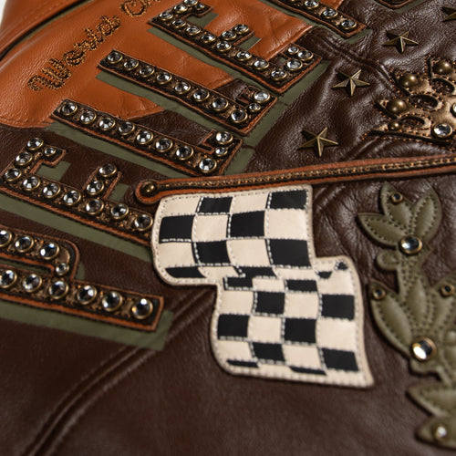 Women's brown colorblock leather racing jacket, checkered flag applique detail, with caramel and olive panels and decorative metallic accents.