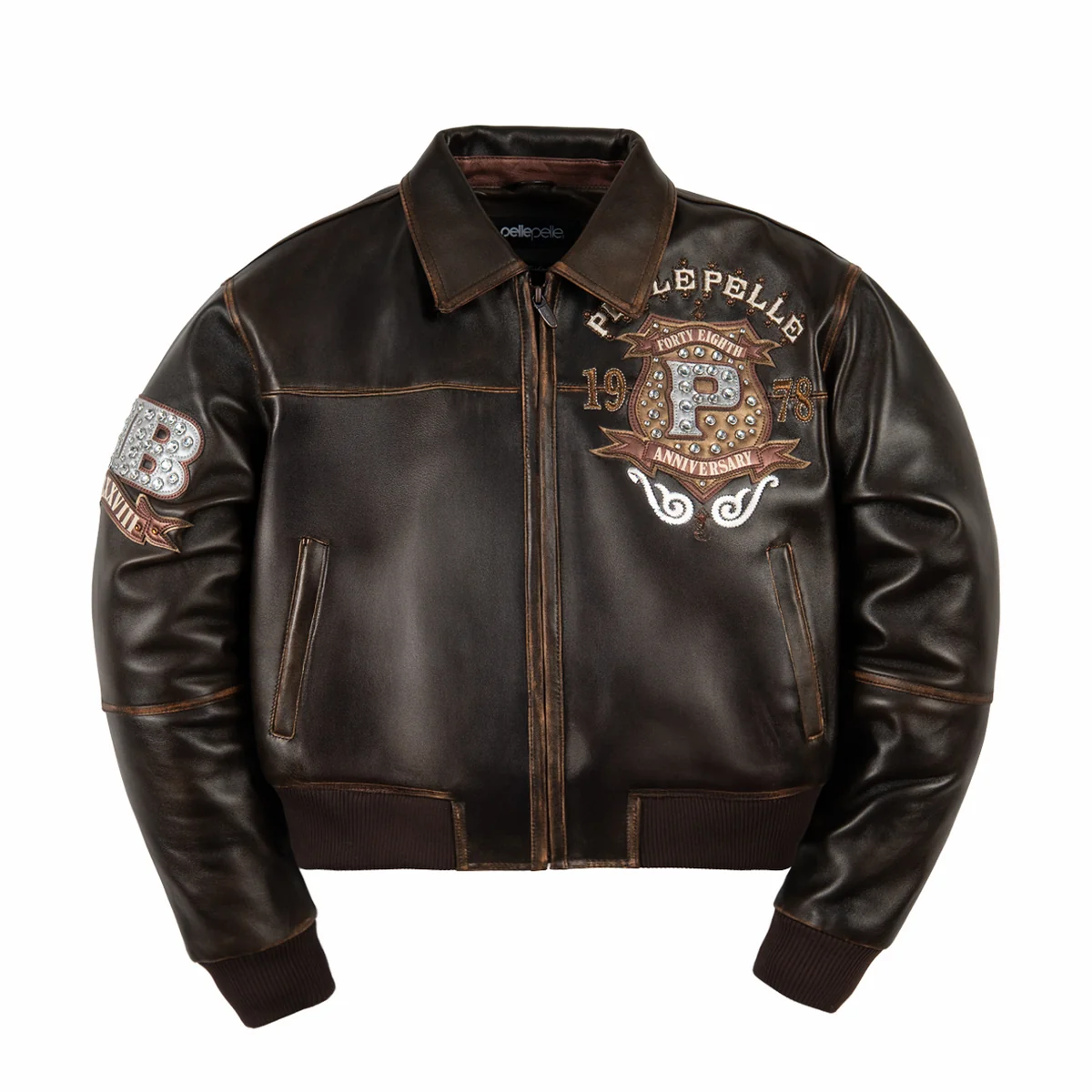 Women's distressed brown leather anniversary jacket, front view, with cream lettering, layered crest artwork, and reflective embellishments.