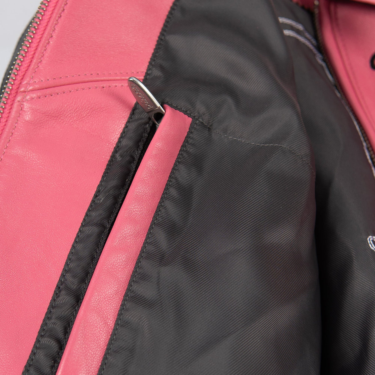 Women's pink and black leather varsity jacket, interior trim close-up, featuring contrast panels and decorative lettering in the product photo.