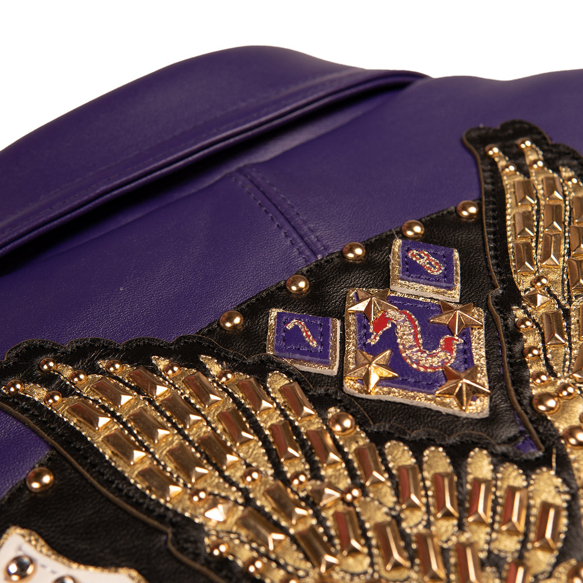 Women's purple leather bomber jacket, gold eagle applique detail, with gold-toned embellishments, cream accents, and decorative crest artwork.