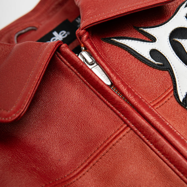 Women's red orange gradient leather bomber jacket, front zipper close-up, showing contrasting black and white graphics and warm-toned panels.