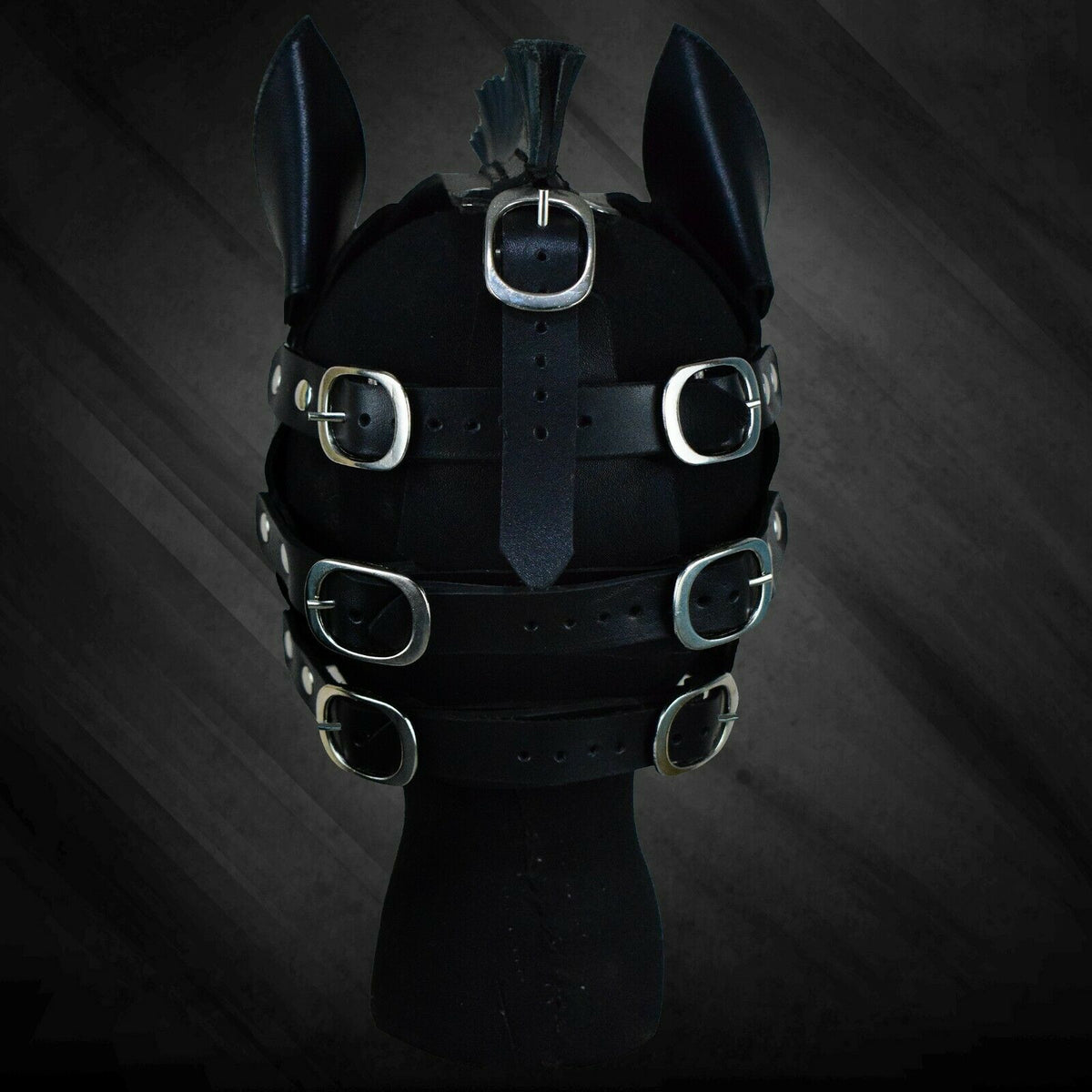 Rear view of black leather horse mask showing multiple silver-tone buckles, adjustable black straps, pointed ears and central crown strap.