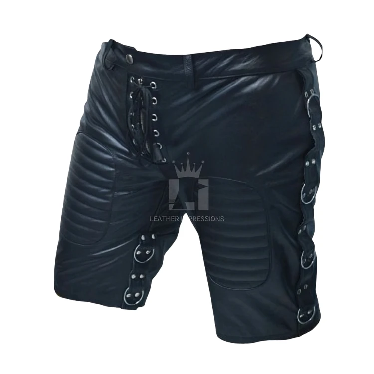Angled view of men's black leather shorts showing ribbed thigh panels, rows of silver-tone side rings, riveted tabs and lace-up front.