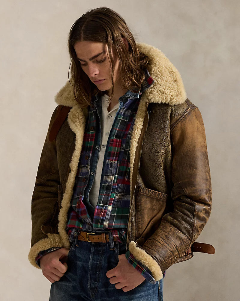 Angled front view of men's brown leather aviator jacket worn open, showing cream collar and cuff trim, zip front and waist adjuster.
