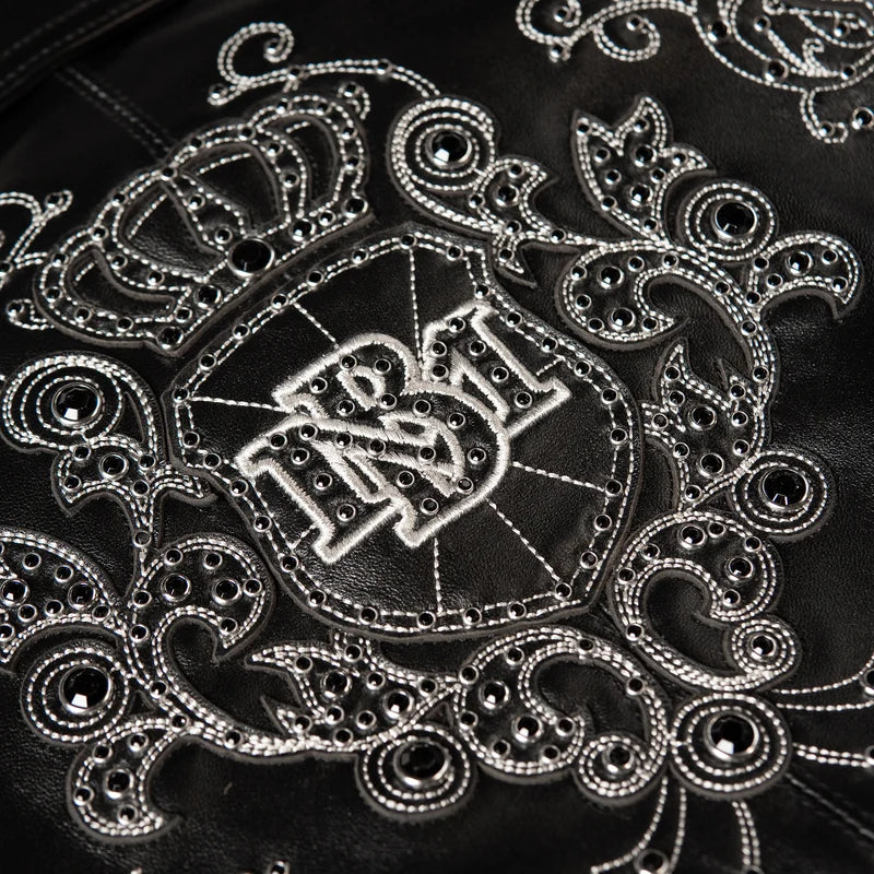 Close-up of the black Pelle Pelle Shoulder Crest jacket with silver-tone stitching, metallic studs and a decorative crowned crest.
