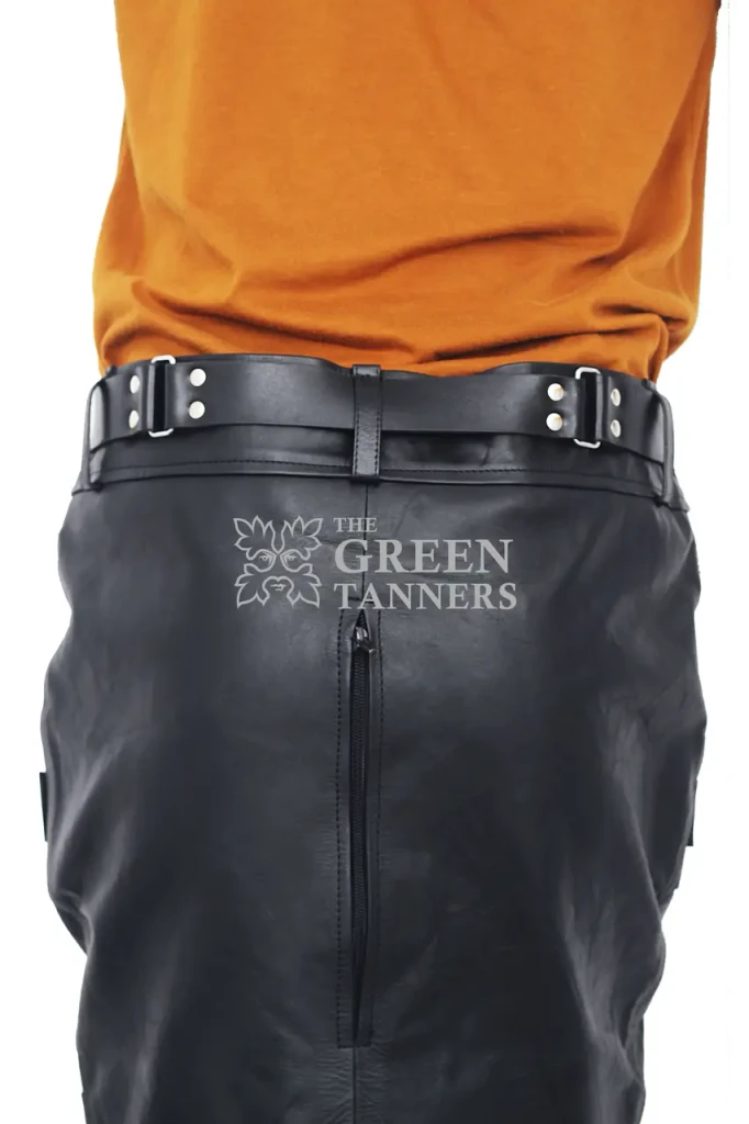 Rear waist detail of black leather leg binder showing adjustable side buckle straps, belt loops, center seam and a vertical zipper.