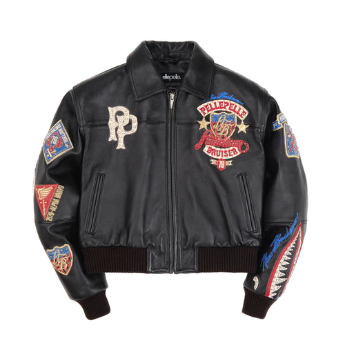 Women's black leather eagle patch bomber jacket, front view with colorful chest patches, zip closure, pointed collar and ribbed trim.
