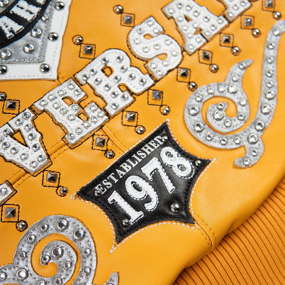 Lower back detail of yellow leather jacket showing embellished anniversary lettering, 1978 patch, scroll motifs and ribbed waistband.