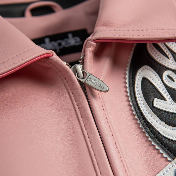 Collar and zipper detail of pale pink genuine leather jacket showing stitched edges, silver-tone pull and layered black chest applique.